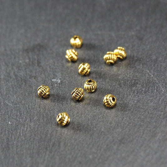 10 kleine Perlen 4mm, geriffelt, Barrel, antik goldfarben, 10469